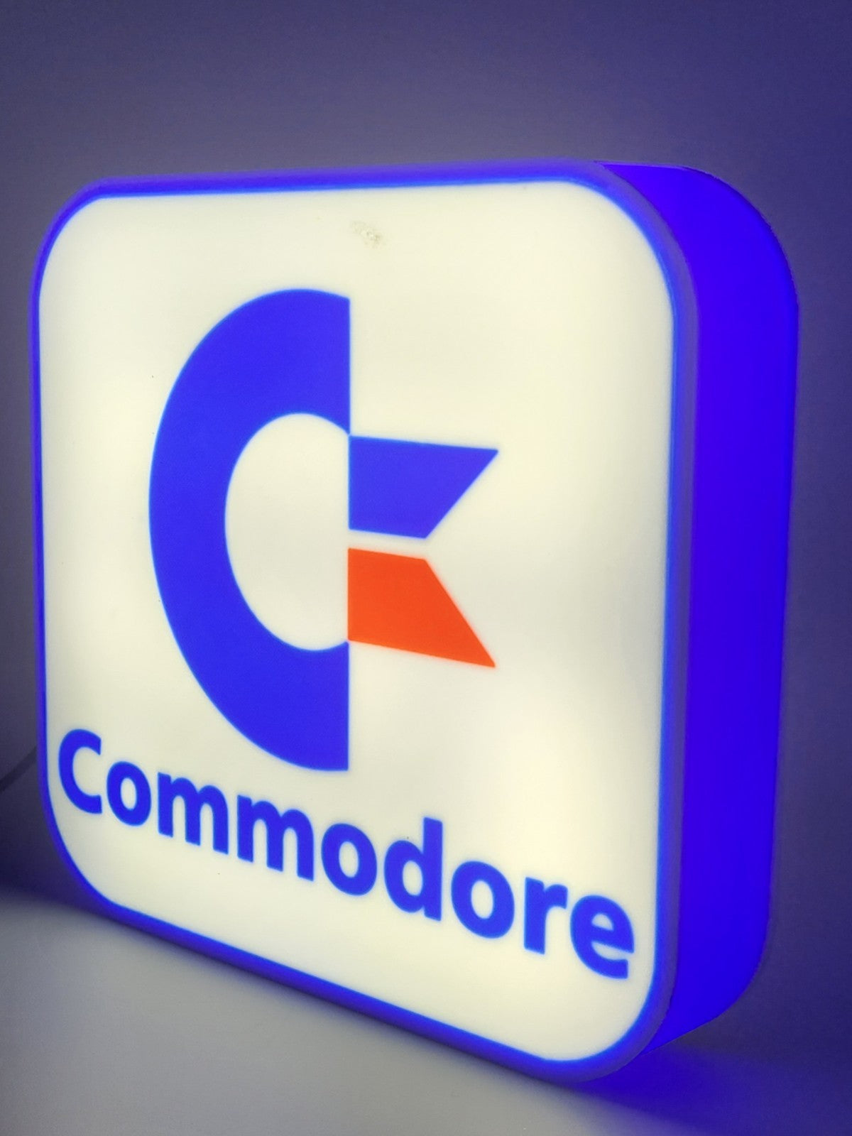 commadore led light sign with illuminated logo viewed from side view