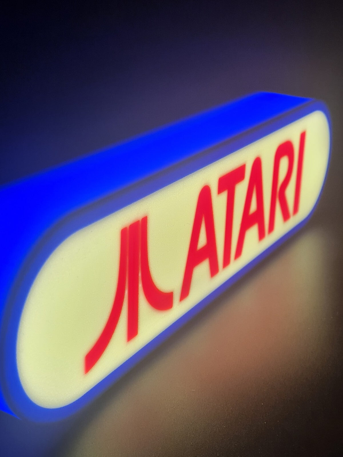 Atari LED light sign with illuminated logo viewed from side view