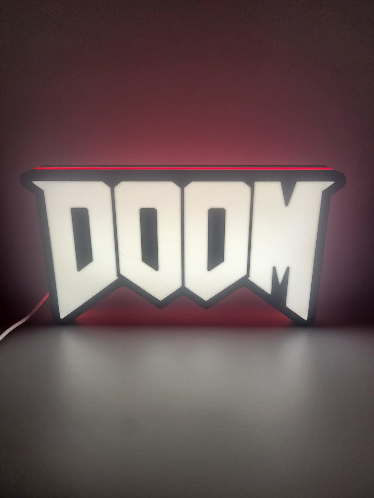Doom LED light sign with illuminated logo viewed from straight on