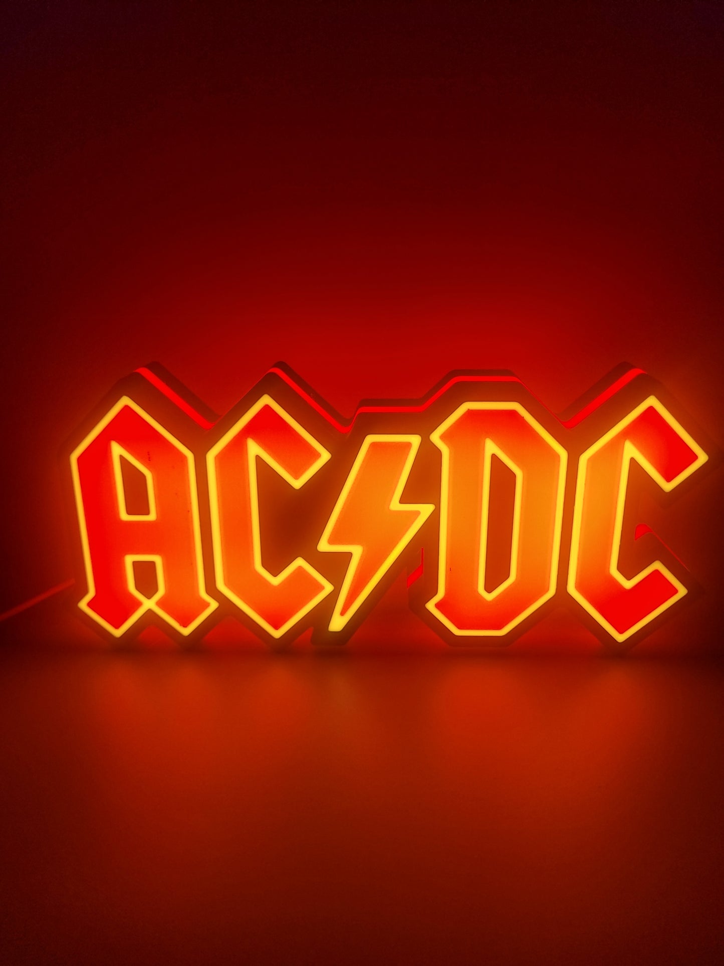 AC/DC LED light sign with illuminated logo viewed from straight on