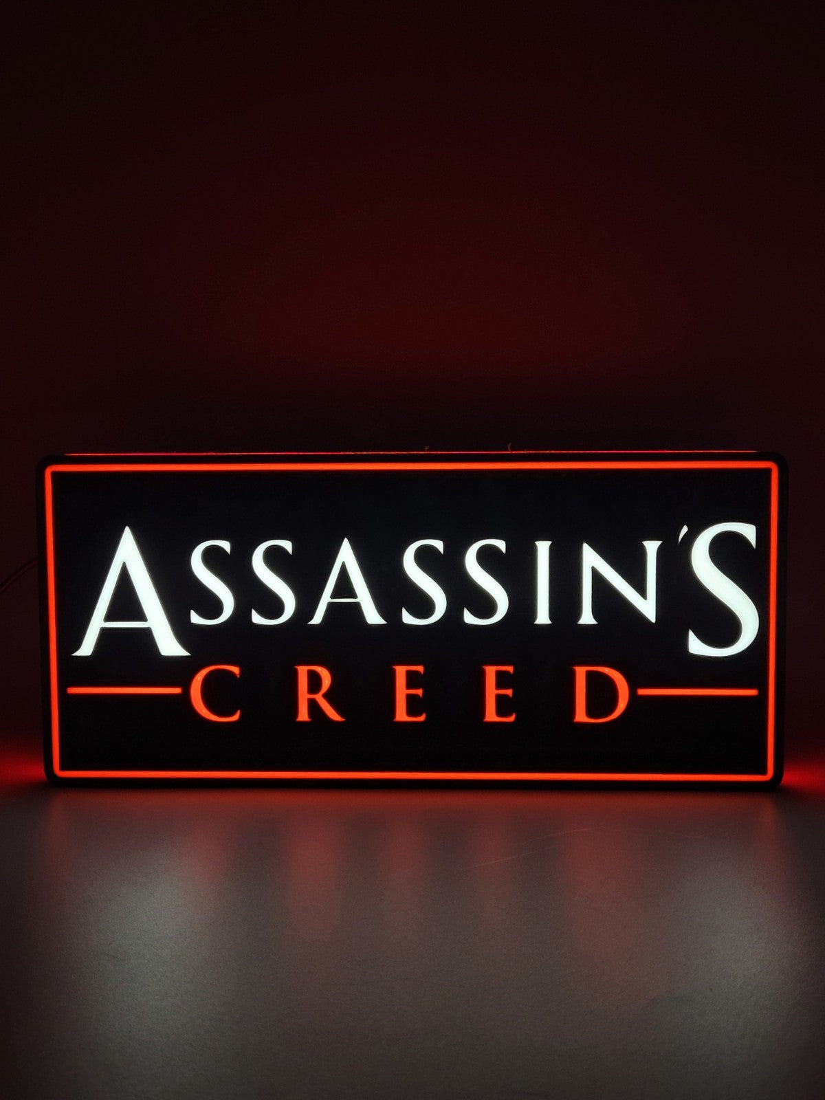 Assassin's Creed LED light sign with illuminated logo viewed from straight on