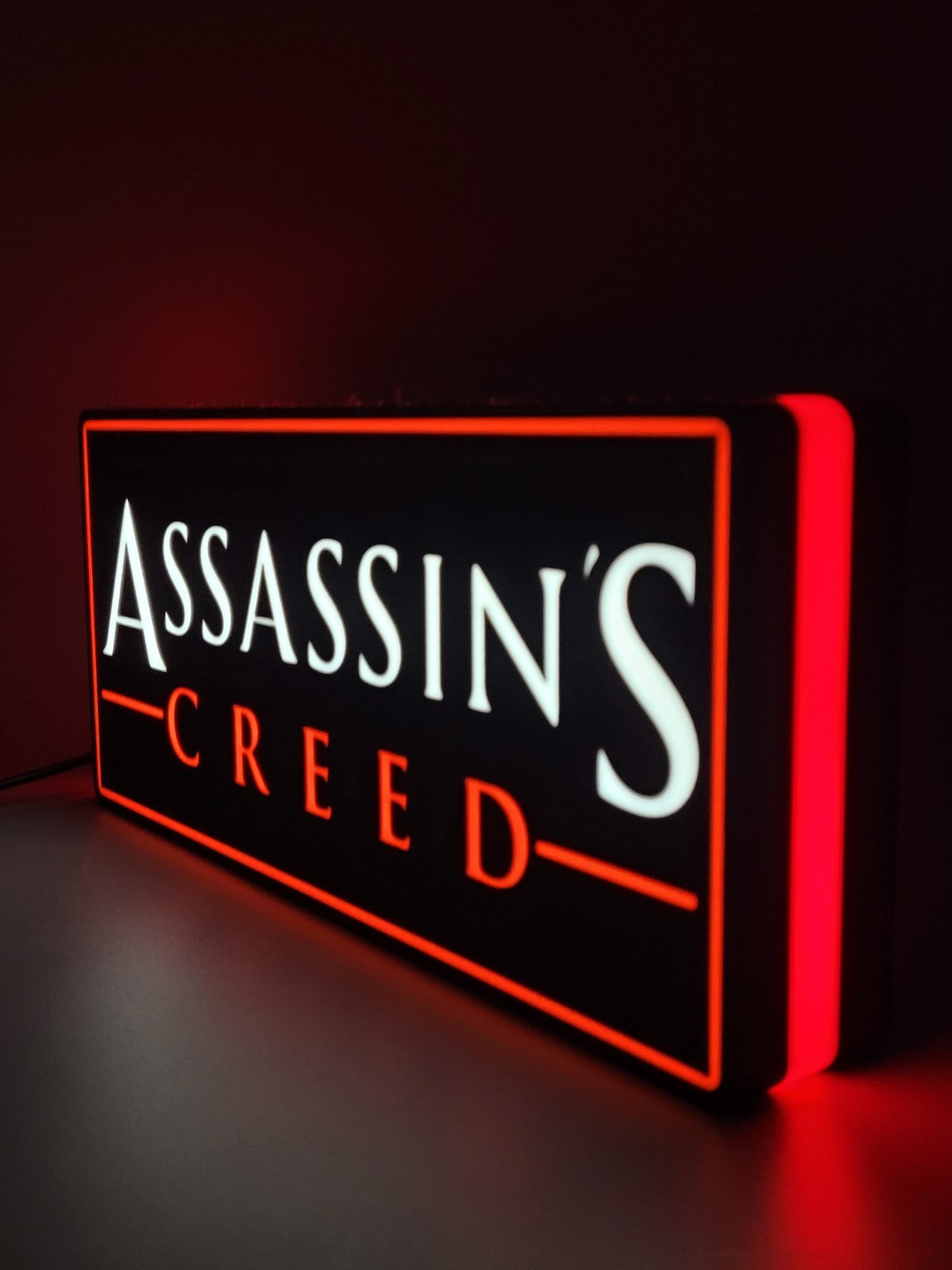 assassin's creed led light sign with illuminated logo viewed from side view