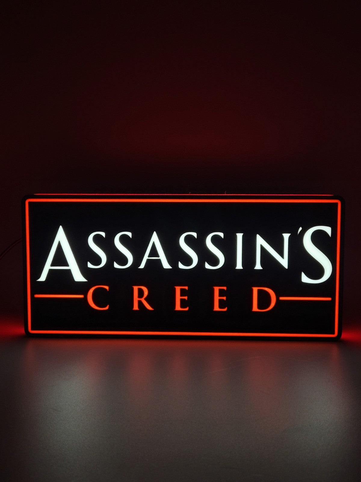 Assassin's Creed LED light sign with illuminated logo viewed from straight on