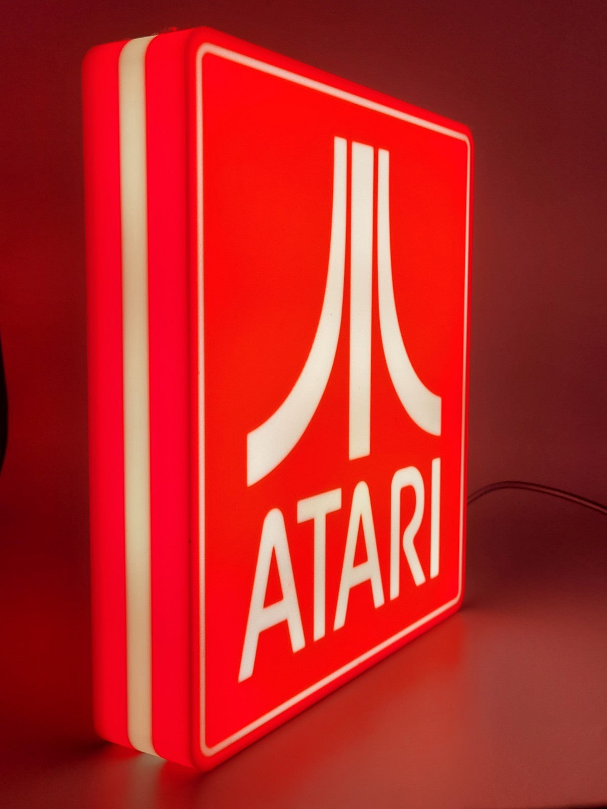 Atari LED light sign with illuminated logo viewed from side view
