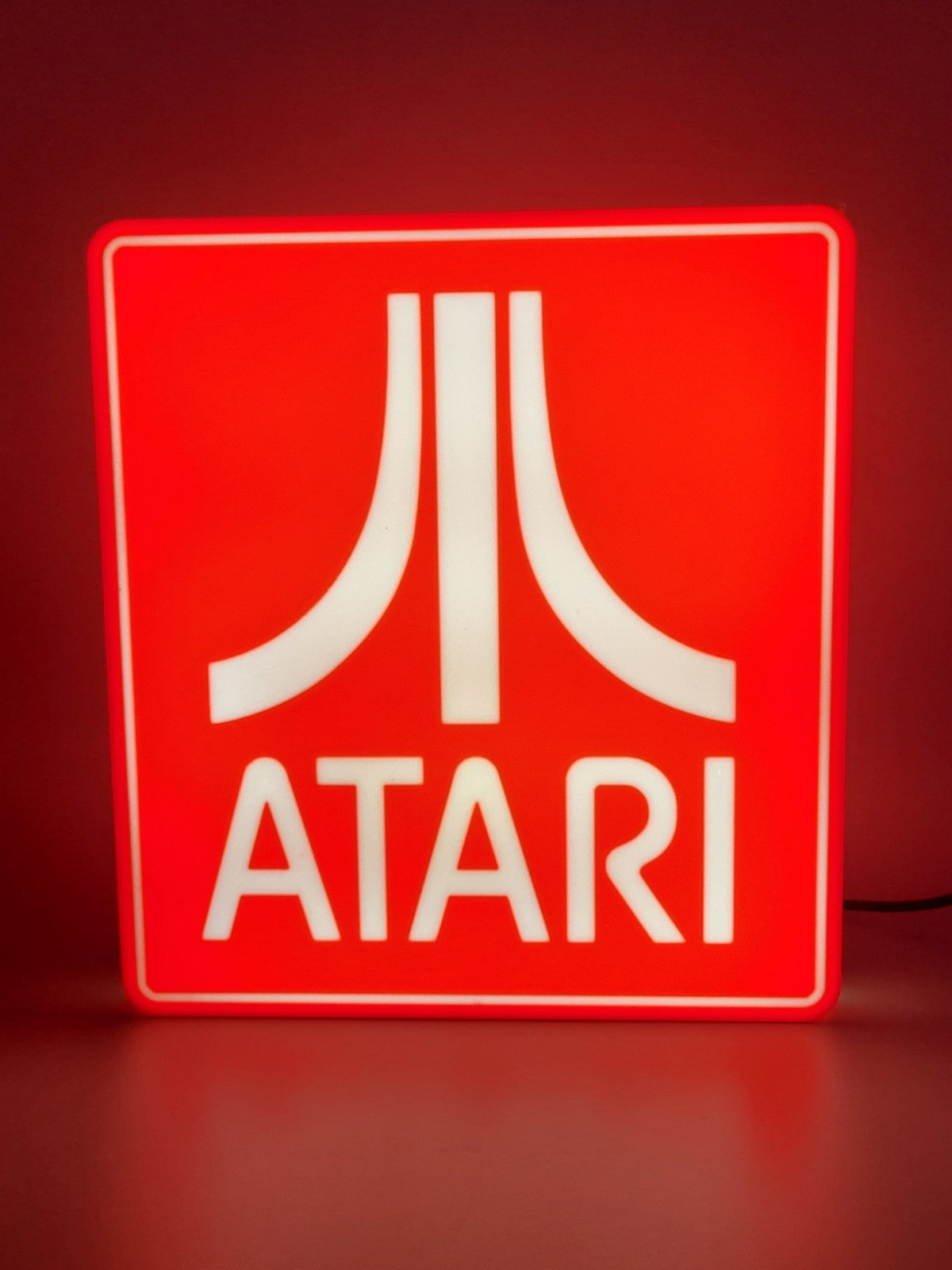 Atari LED light sign with illuminated logo viewed from straight on