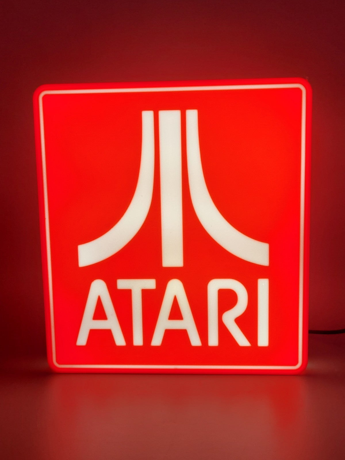 Atari LED light sign with illuminated logo viewed from straight on