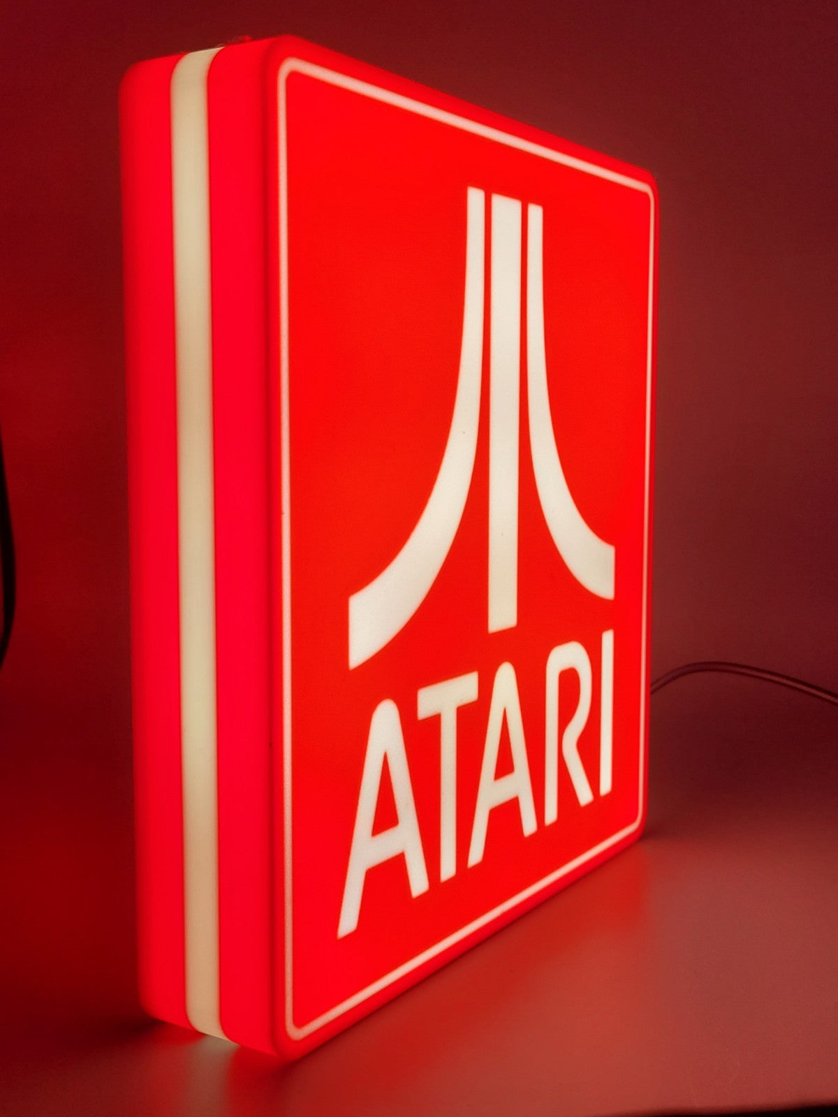 Atari LED light sign with illuminated logo viewed from side view