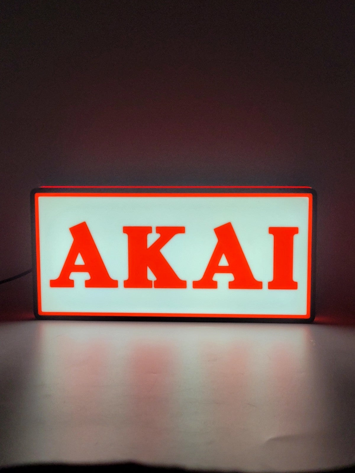 Akai led light sign with illuminated logo viewed from straight on