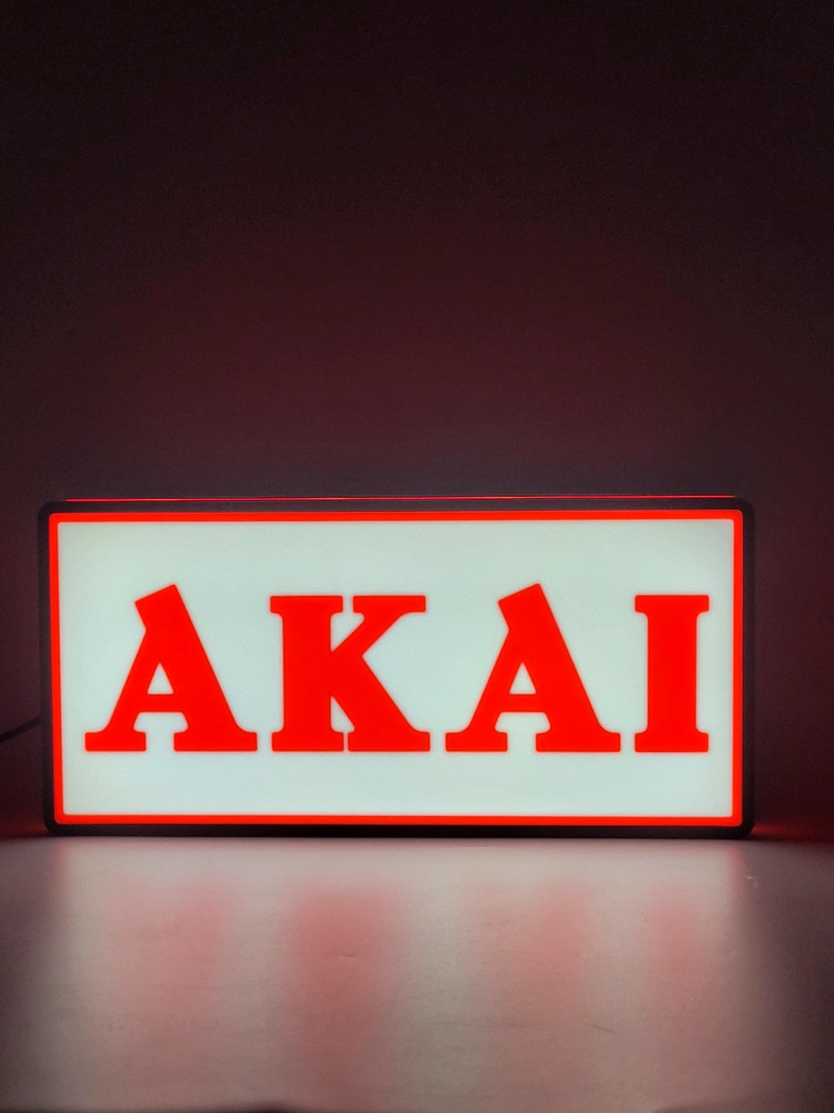 Akai led light sign with illuminated logo viewed from straight on