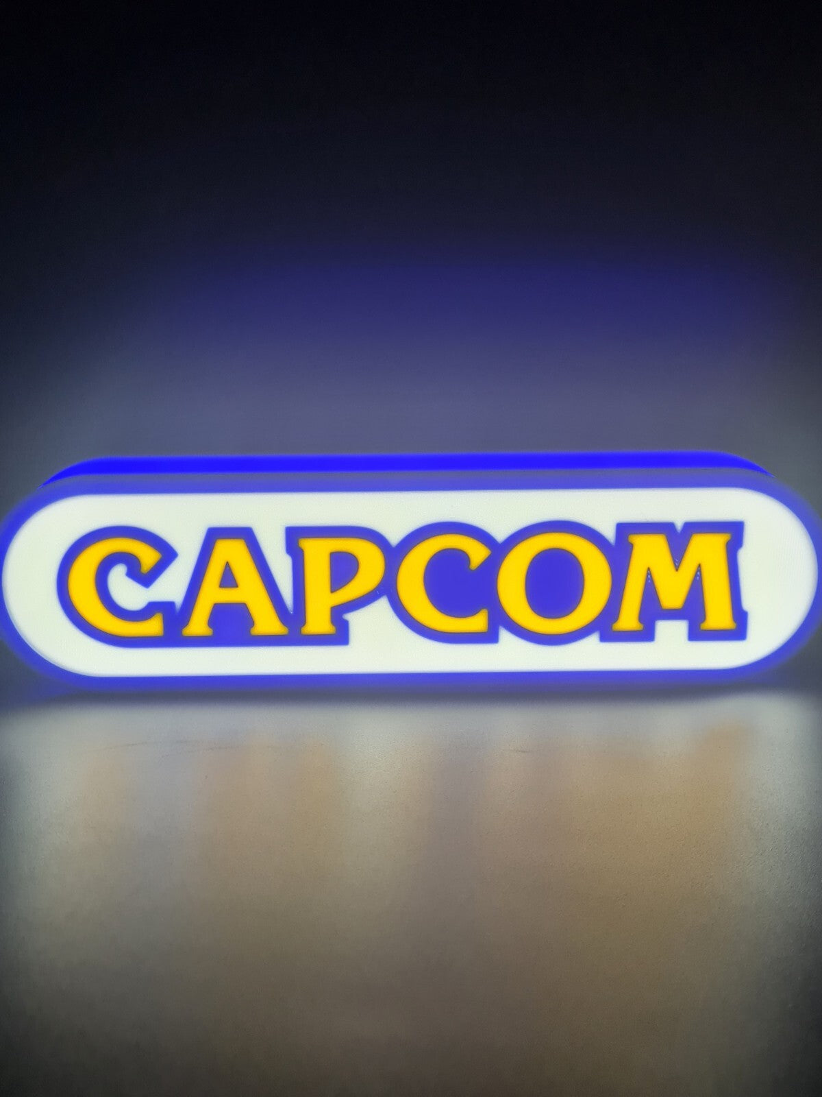 Capcom LED light sign with illuminated logo viewed from straight on