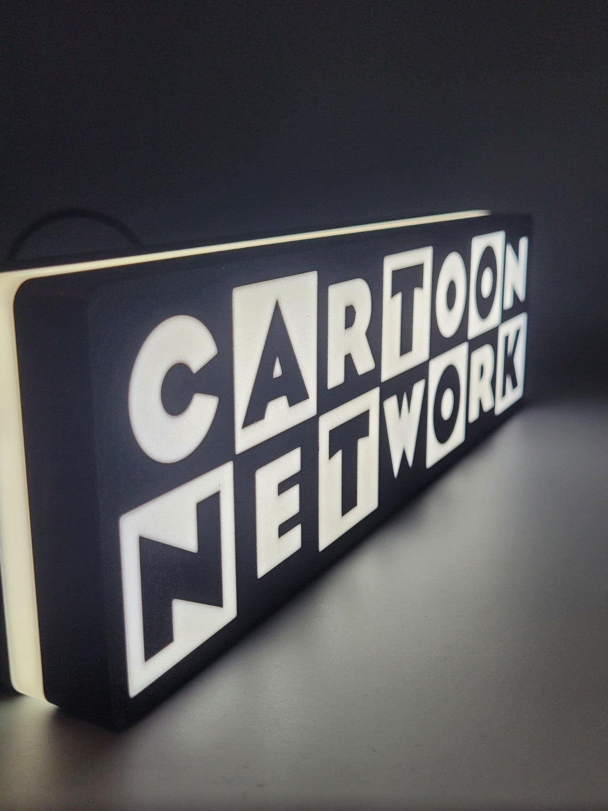 cartoon network LED light sign with illuminated logo viewed from side view