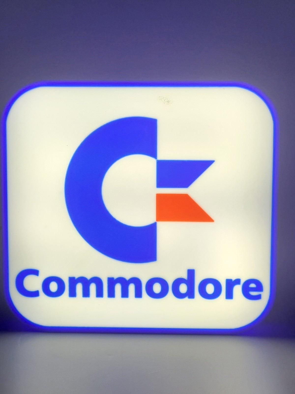 Commodore LED light sign with illuminated logo viewed from straight on
