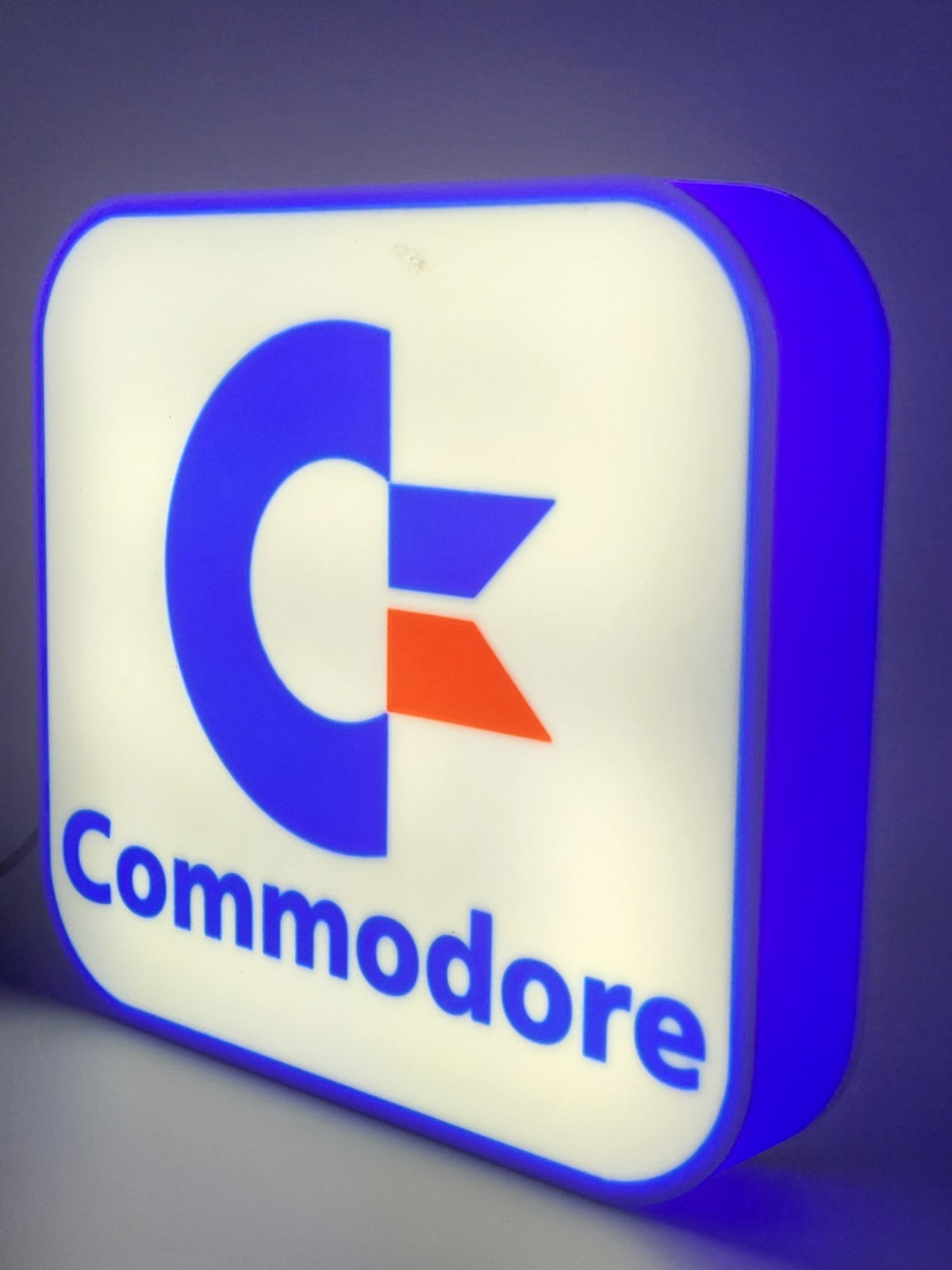 commadore led light sign with illuminated logo viewed from side view