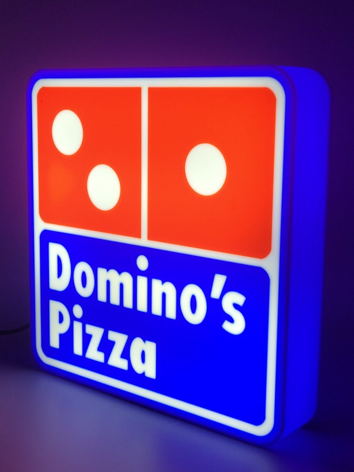 Domino's LED light sign with illuminated logo viewed from side view
