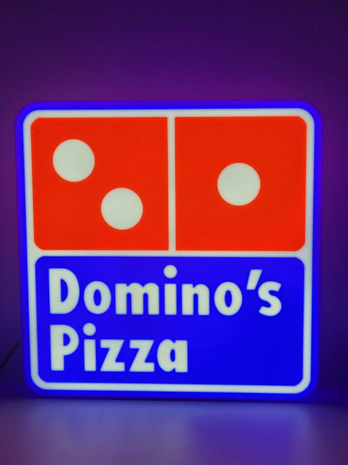 Domino's LED light sign with illuminated logo viewed from straight on