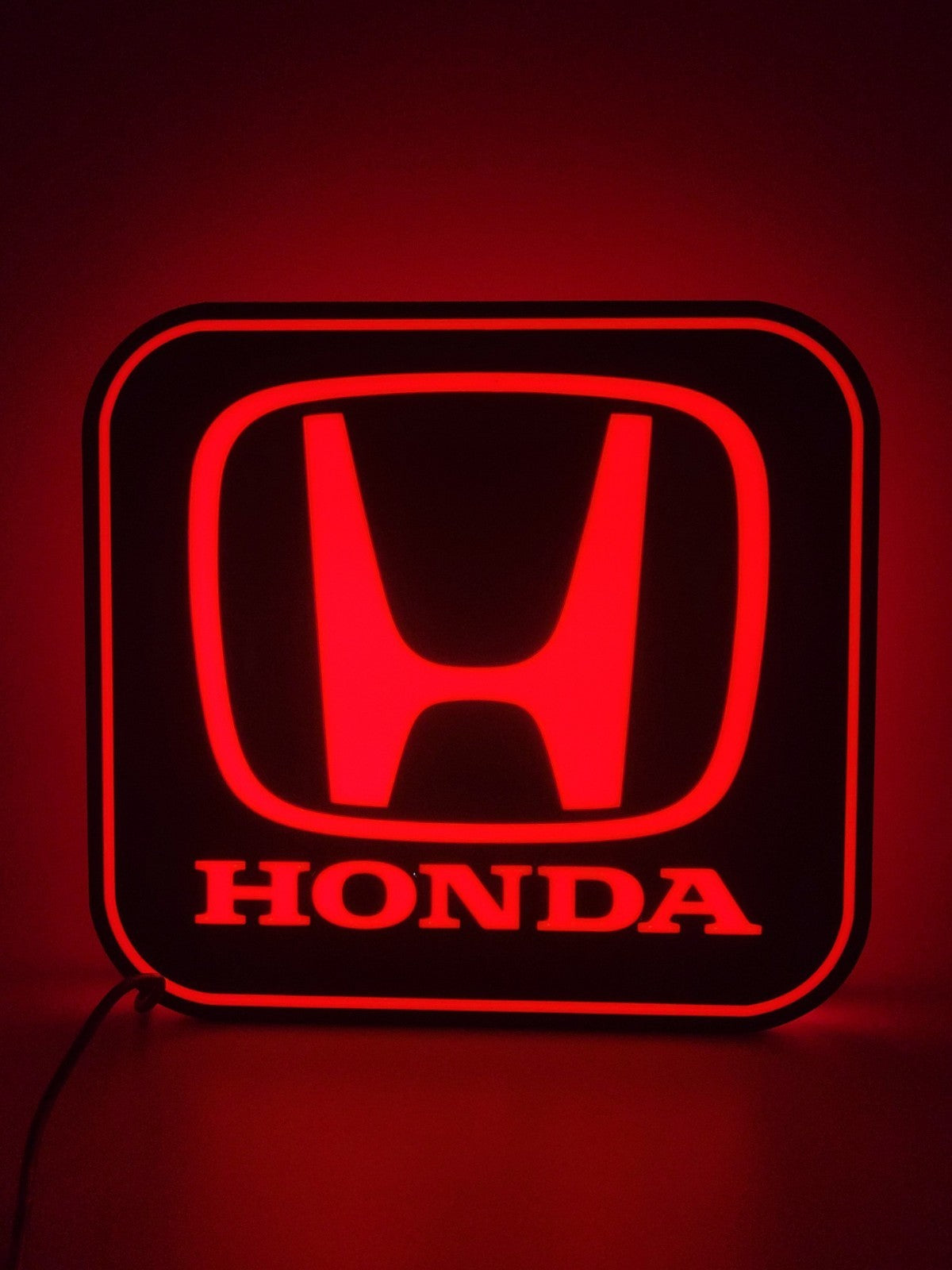 Honda LED light sign with illuminated logo viewed from straight on