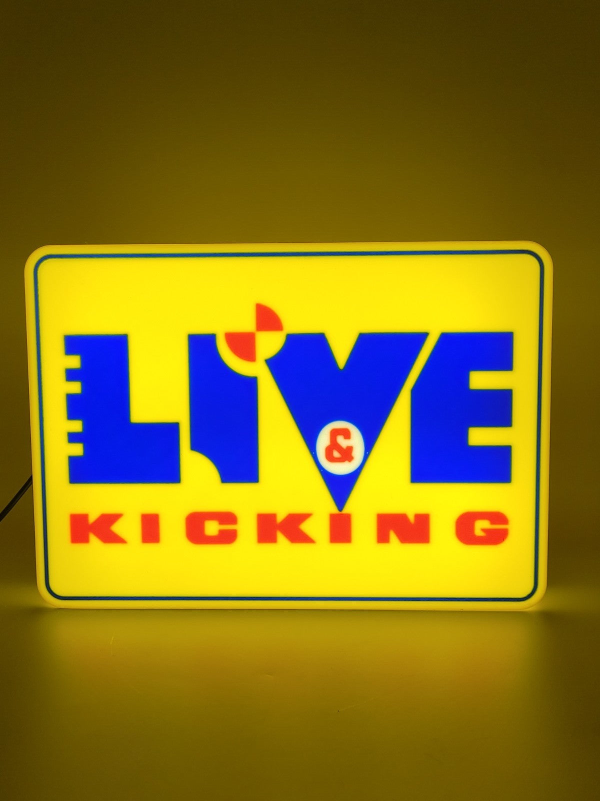 Live And Kicking LED light sign with illuminated logo viewed from straight on