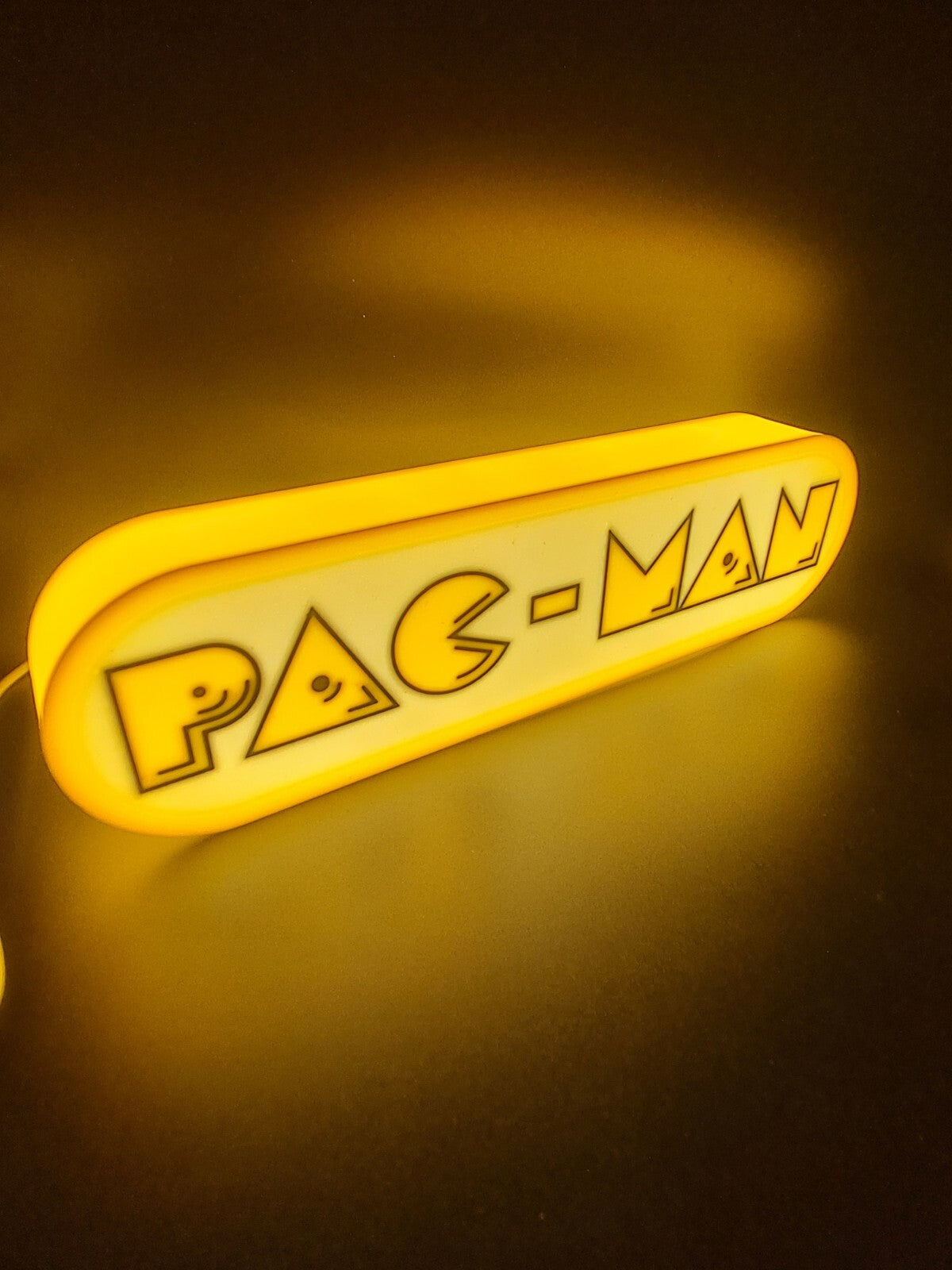 Pac-Man LED light sign with illuminated logo viewed from side view