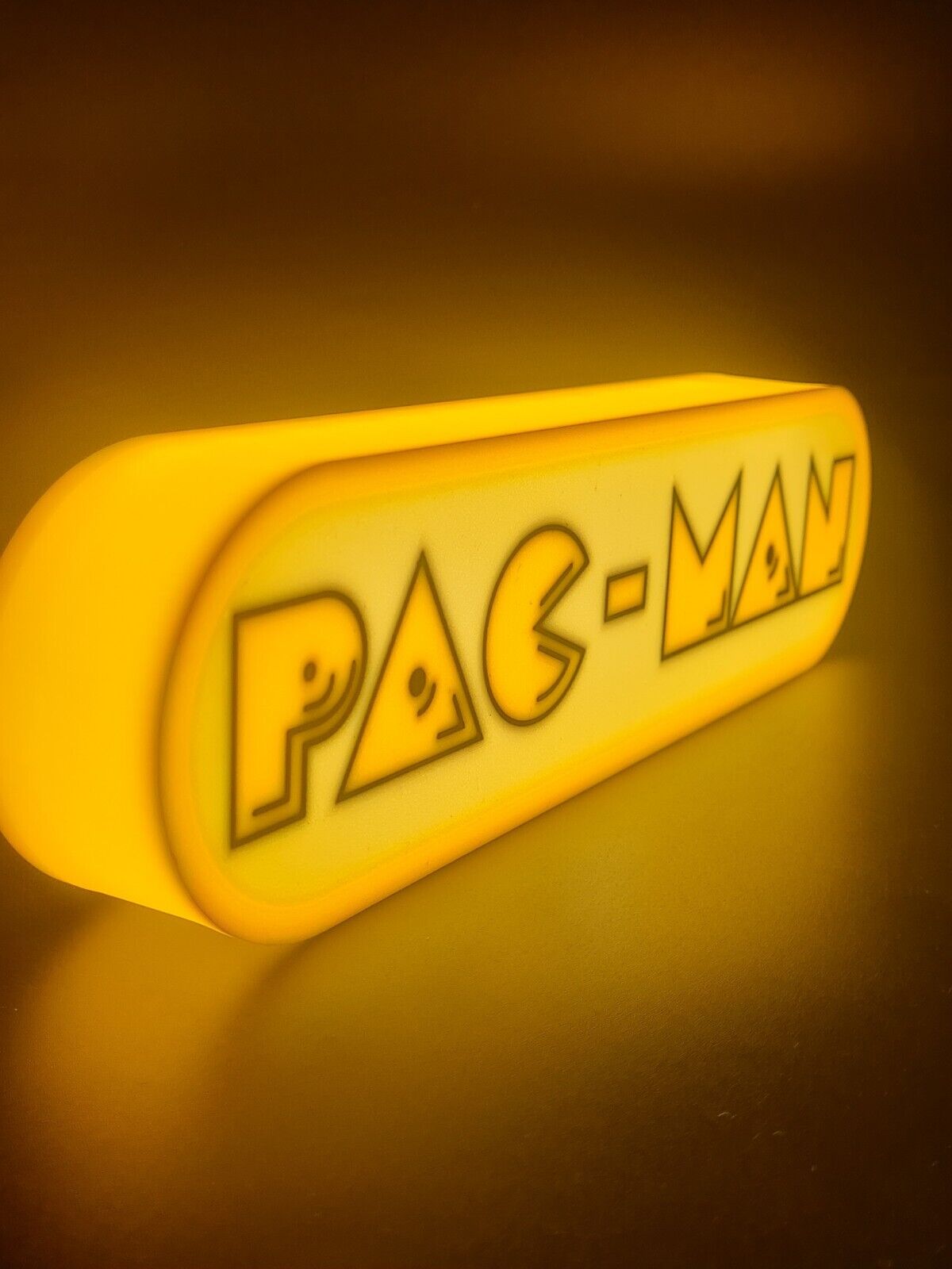 Pac-Man LED light sign with illuminated logo viewed from side view