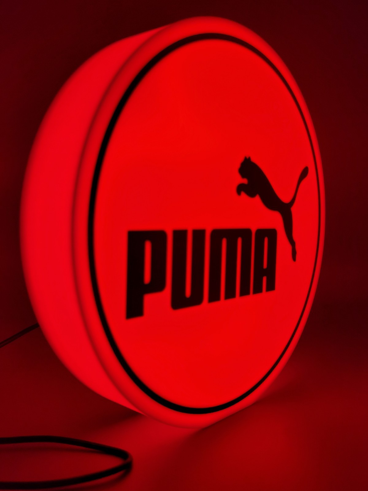 Puma LED light sign with illuminated logo viewed from side view