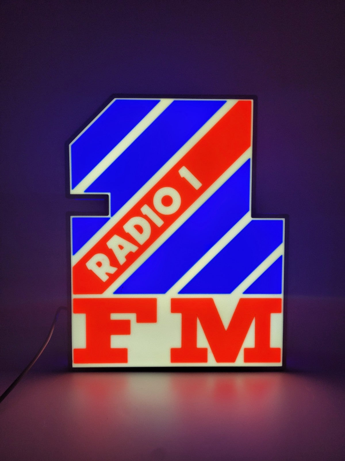 Radio 1 LED light sign with illuminated logo viewed from straight on