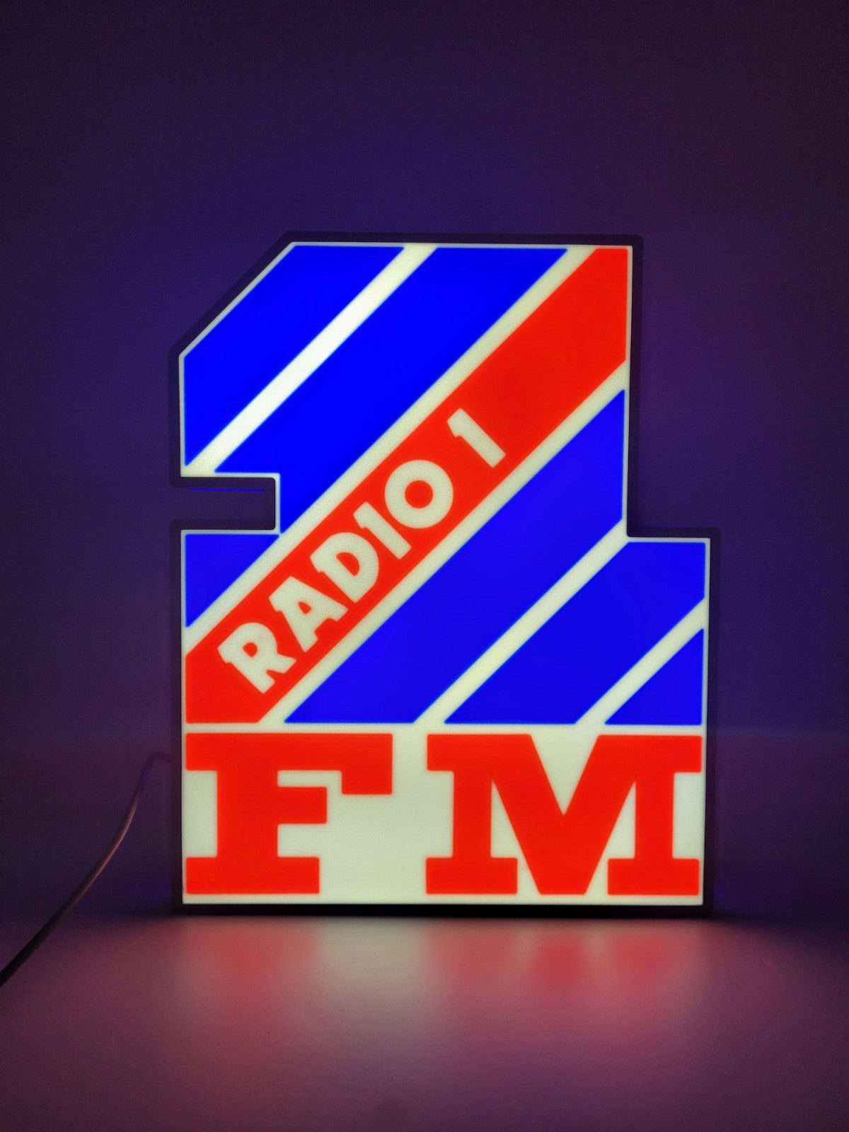 Radio 1 LED light sign with illuminated logo viewed from straight on