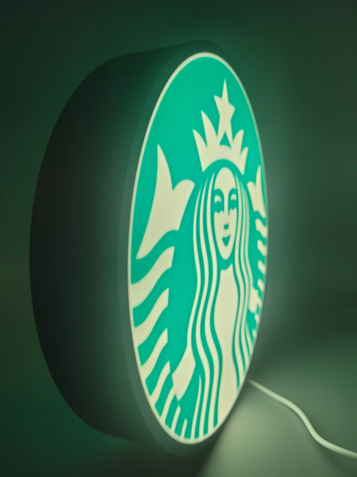 starbucks LED light sign with illuminated logo viewed from side view