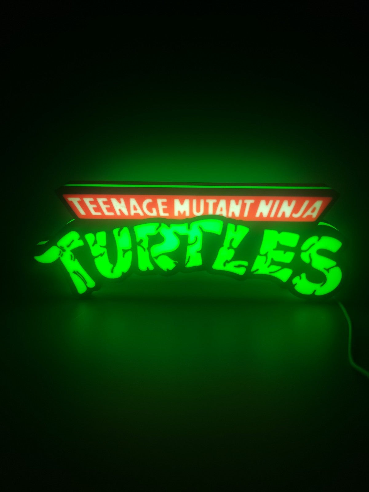 TEANAGE MUTANT NINJA TURTLES LED light sign with illuminated logo viewed from straight on