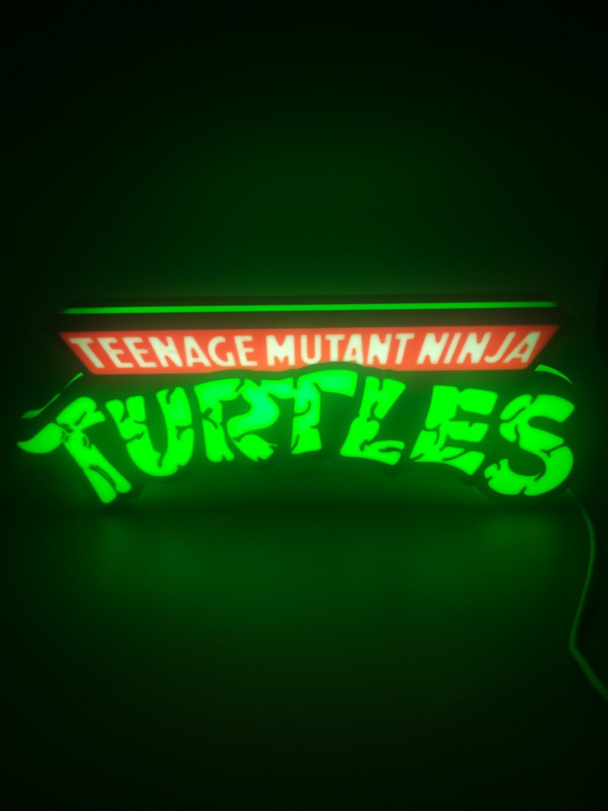TEANAGE MUTANT NINJA TURTLES LED light sign with illuminated logo viewed from straight on