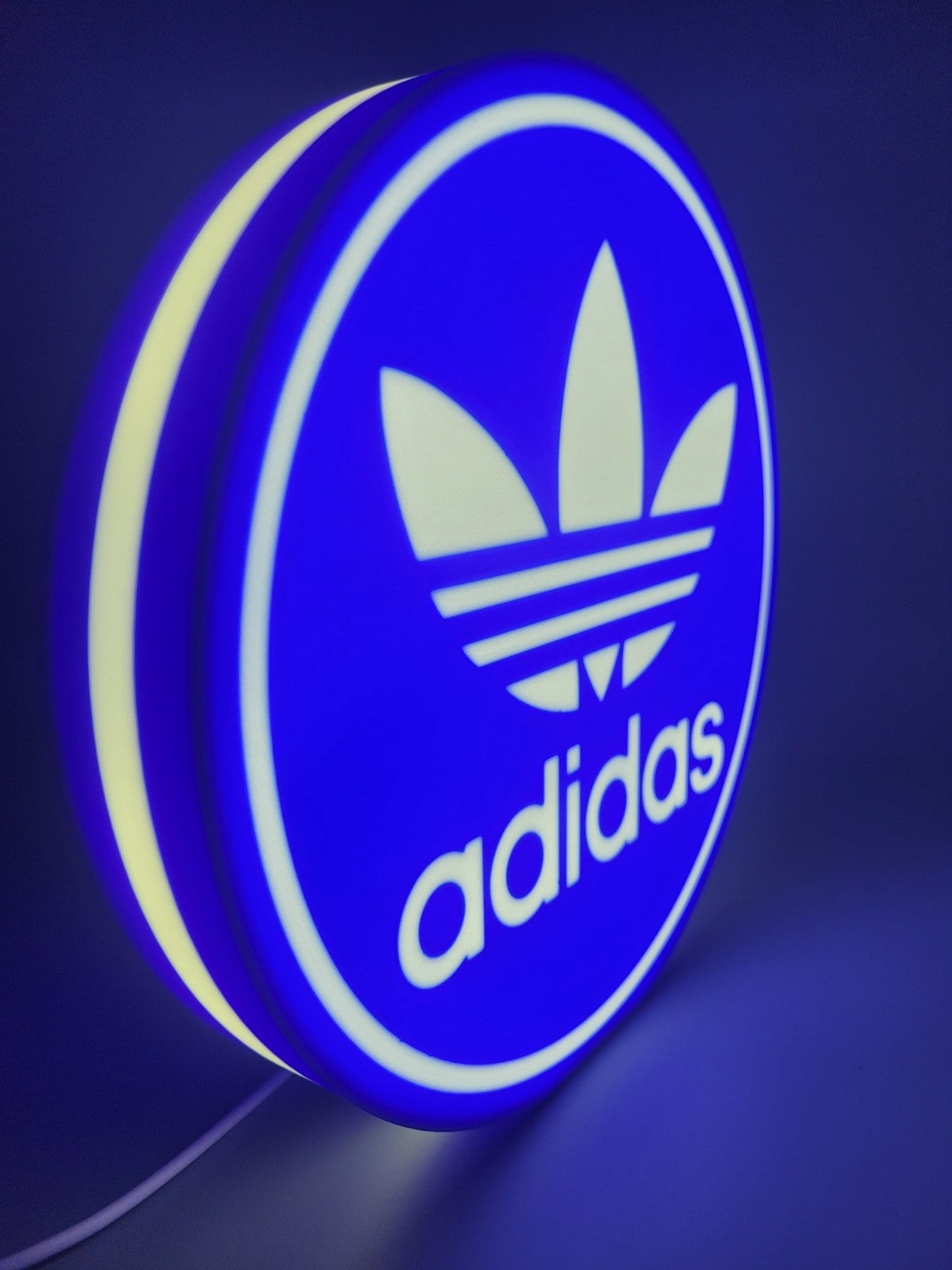 Adidas led light sign with illuminated logo viewed from side view