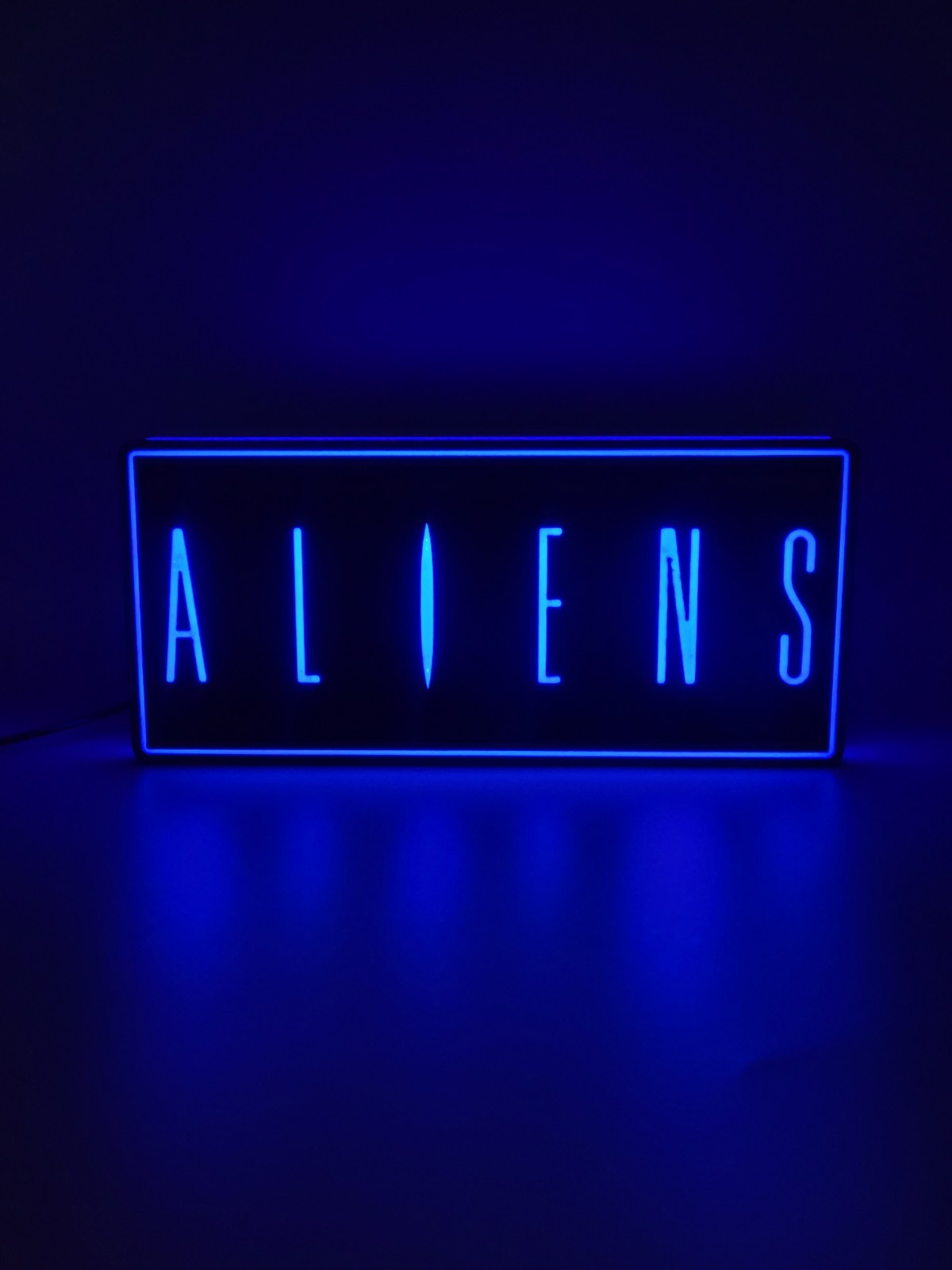 Aliens led light sign with illuminated logo viewed from straight on