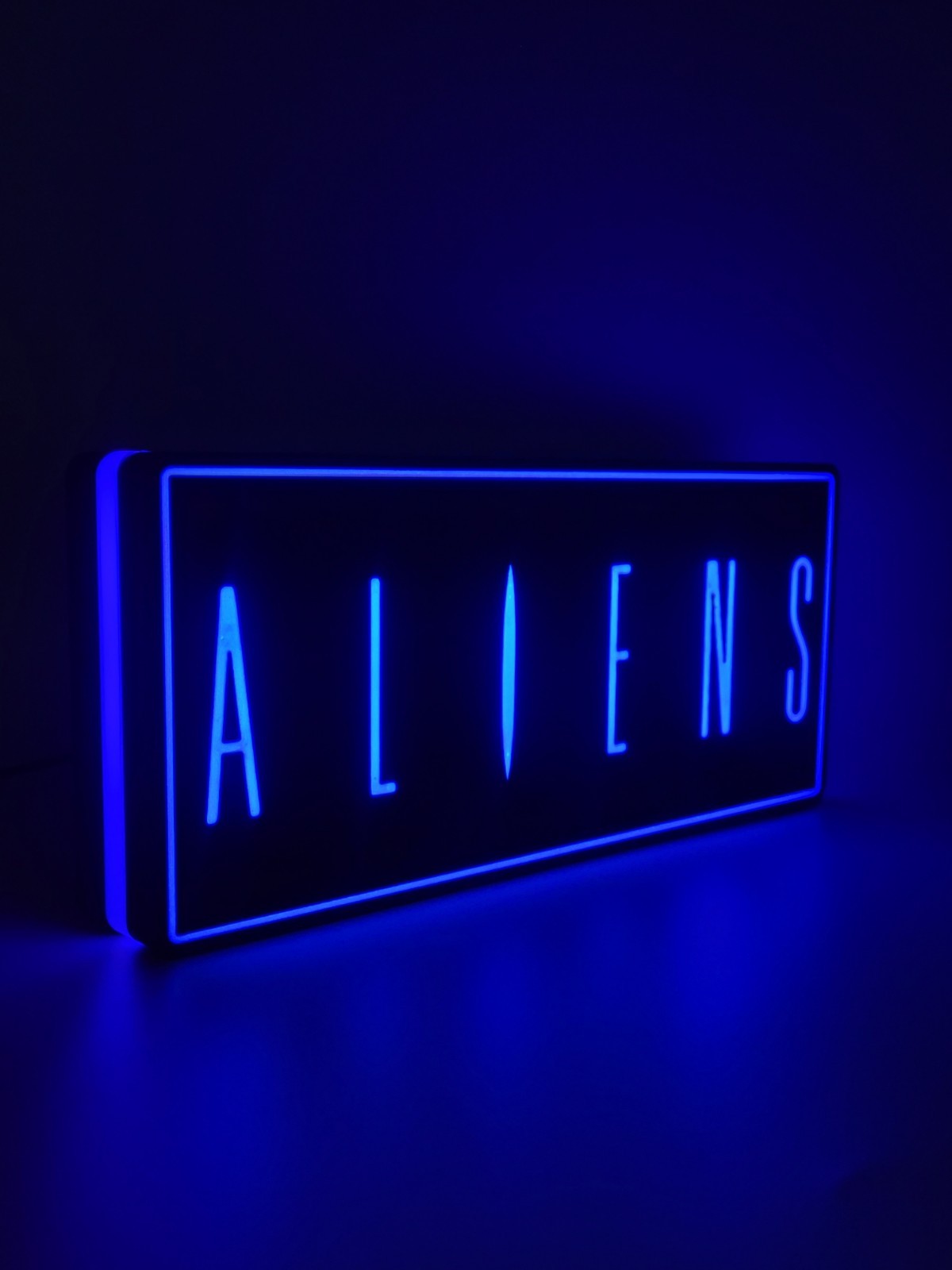 Aliens led light sign with illuminated logo viewed from side view