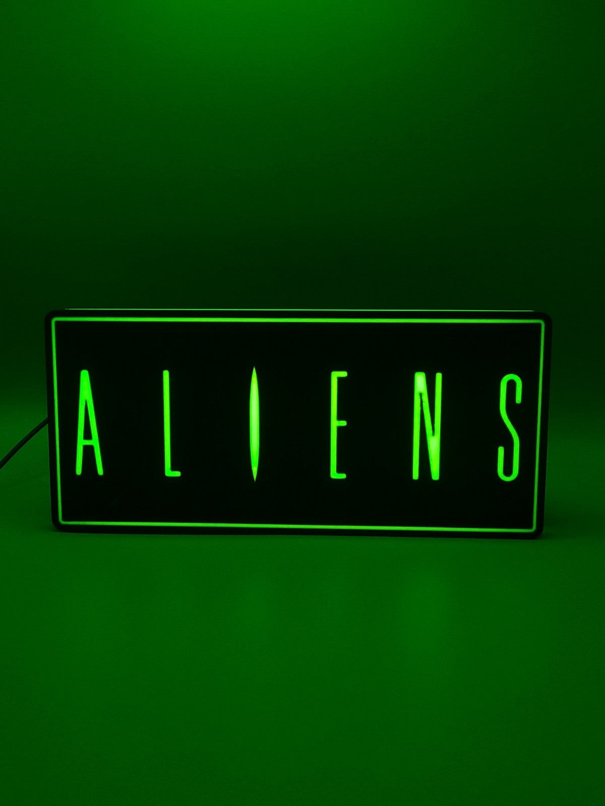 Aliens led light sign with illuminated logo viewed from straight on