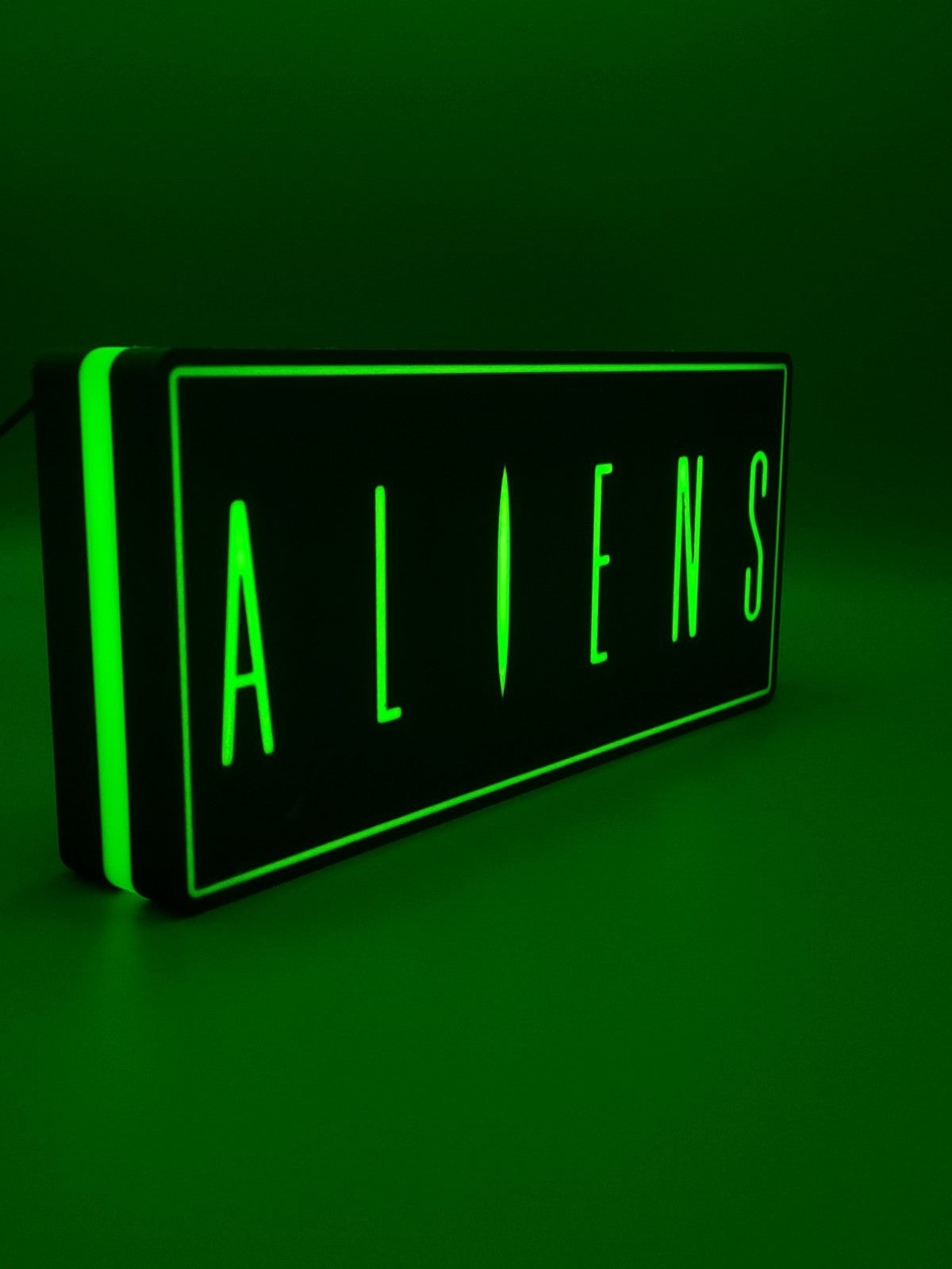 Aliens led light sign with illuminated logo viewed from side view