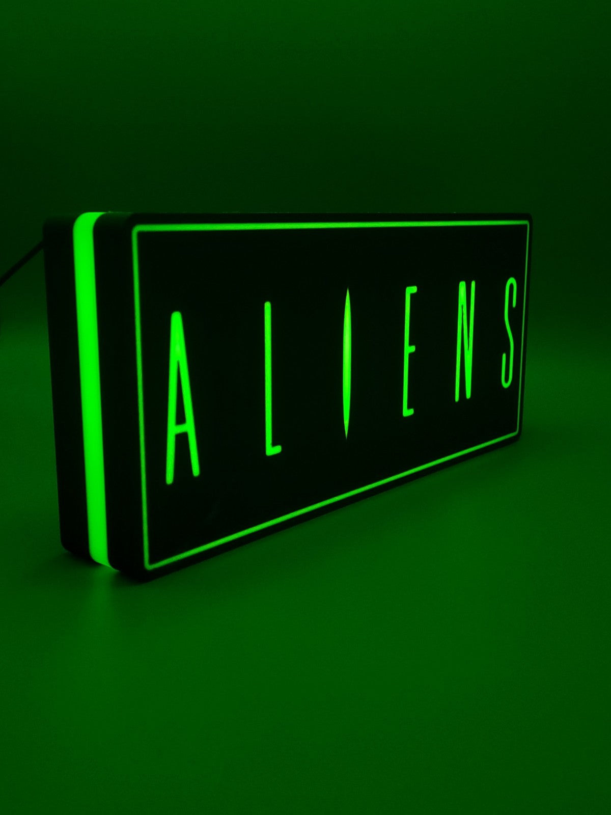 Aliens led light sign with illuminated logo viewed from side view