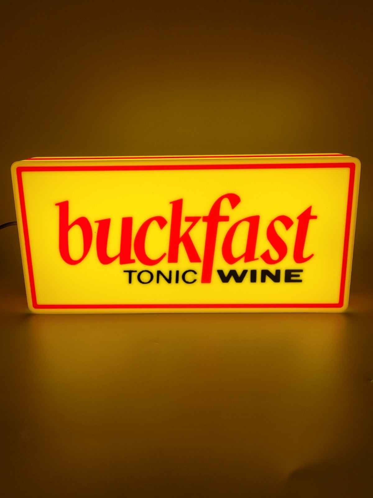 BUCKFAST led light sign with illuminated logo viewed from straight on