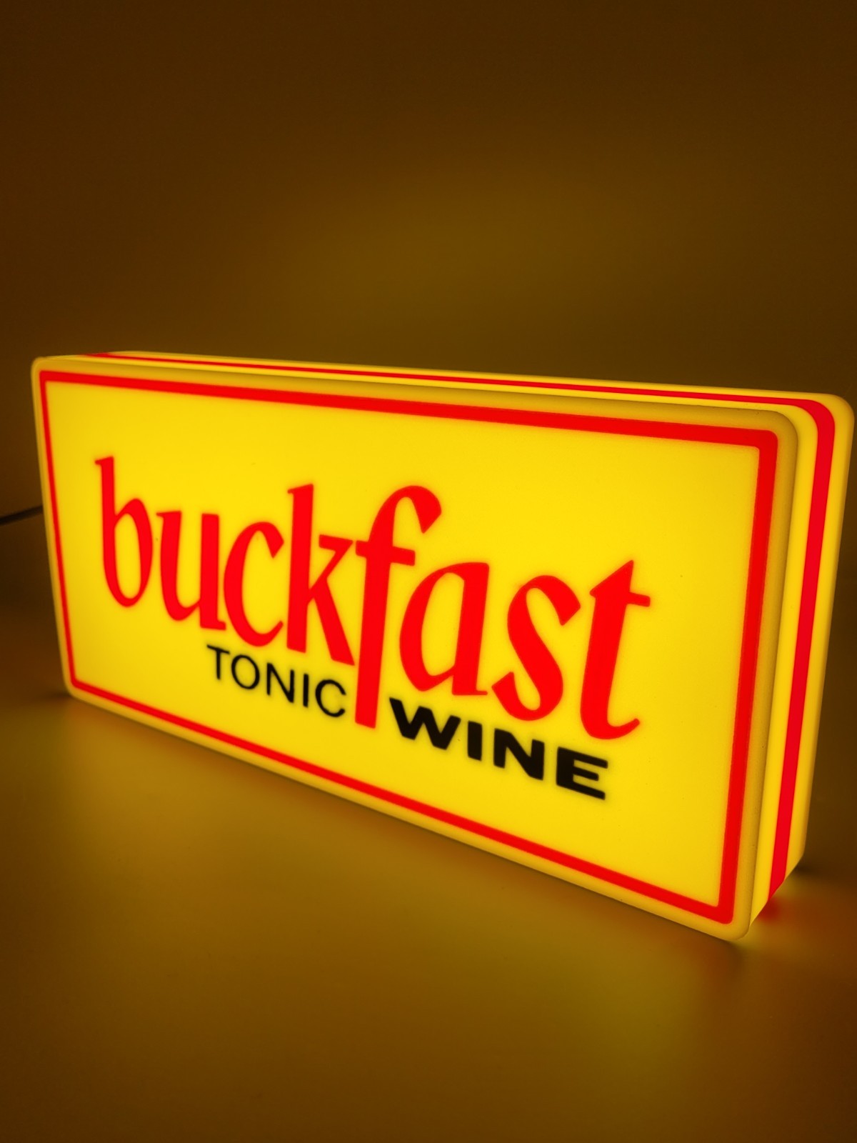 BUCKFAST led light sign with illuminated logo viewed from side view