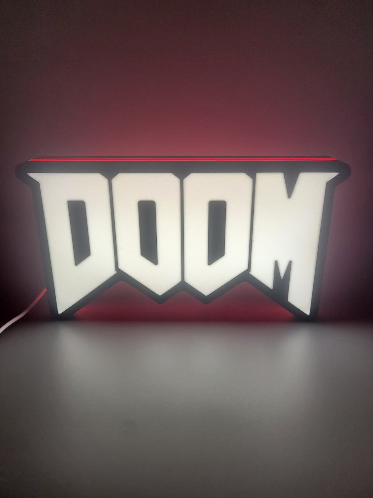 Doom LED light sign with illuminated logo viewed from straight on