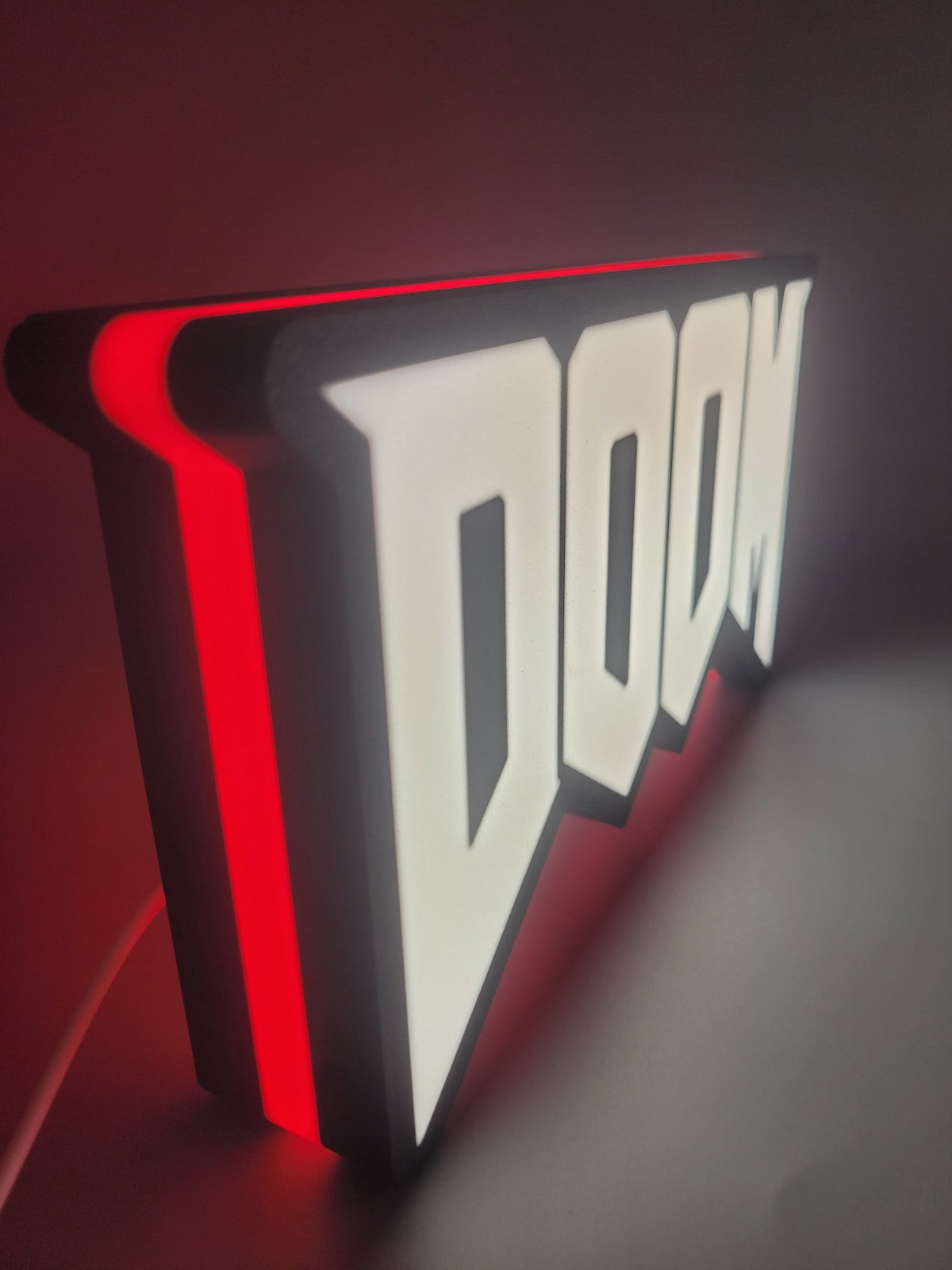 Doom LED light sign with illuminated logo viewed from side view