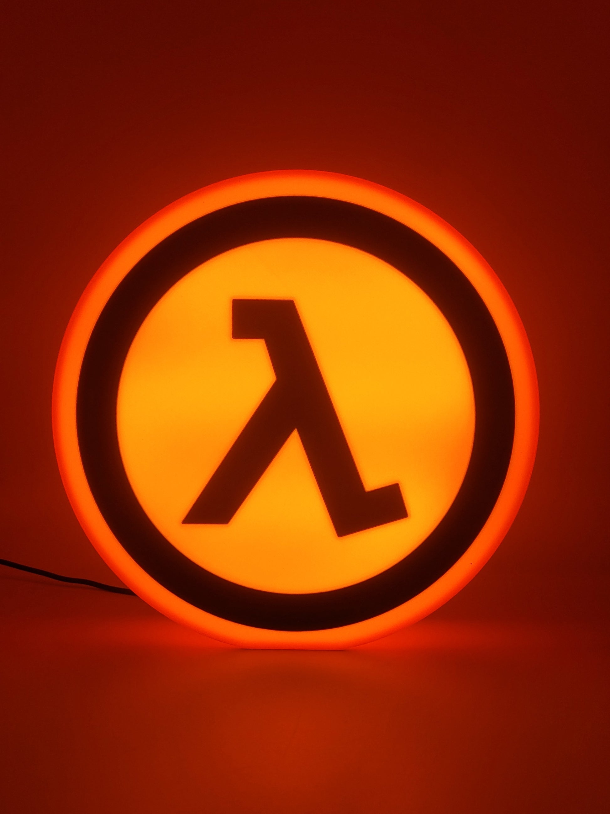 Half-life LED light sign with illuminated logo viewed from straight on