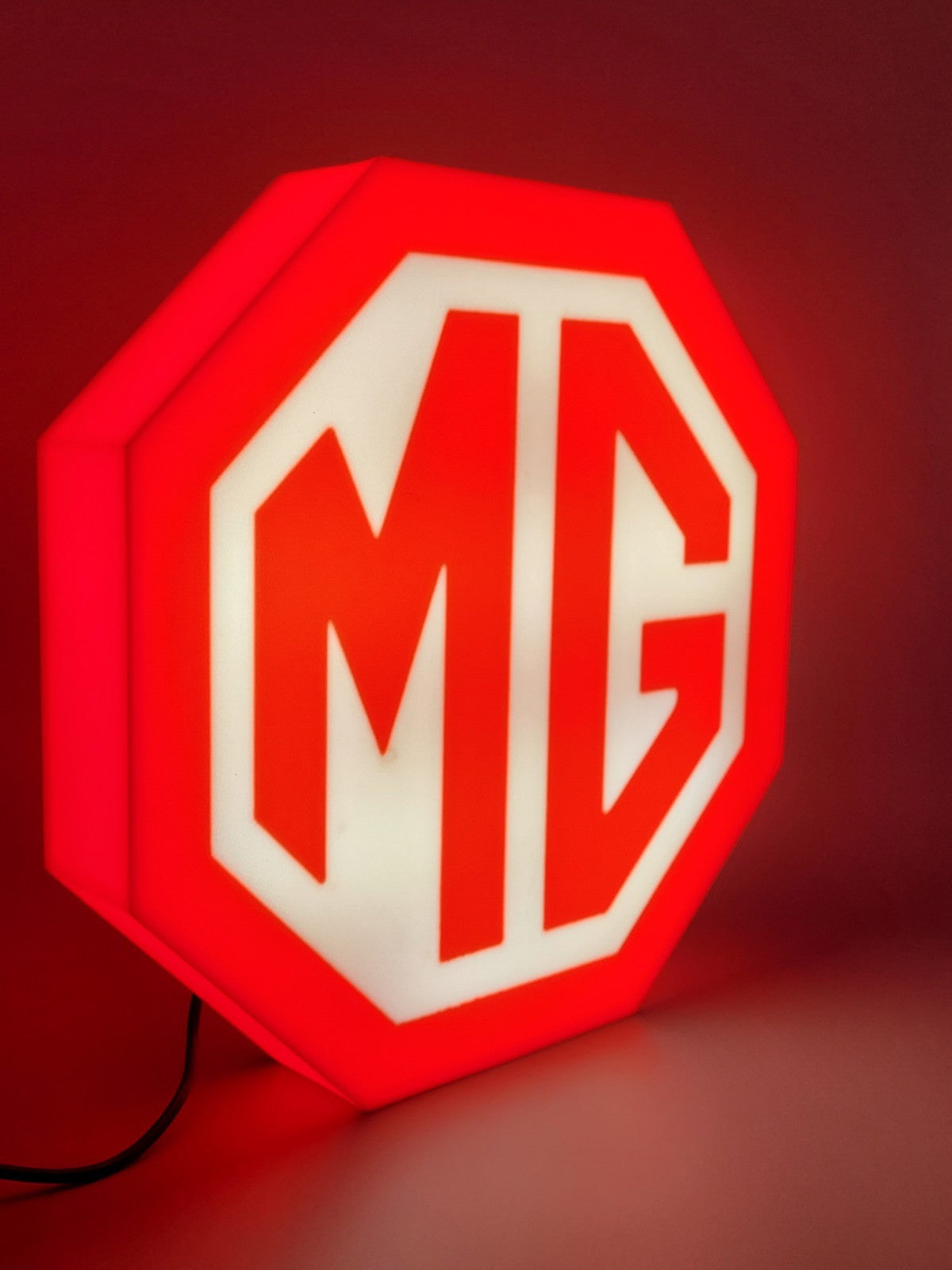 MG led light sign with illuminated logo viewed from side view 
