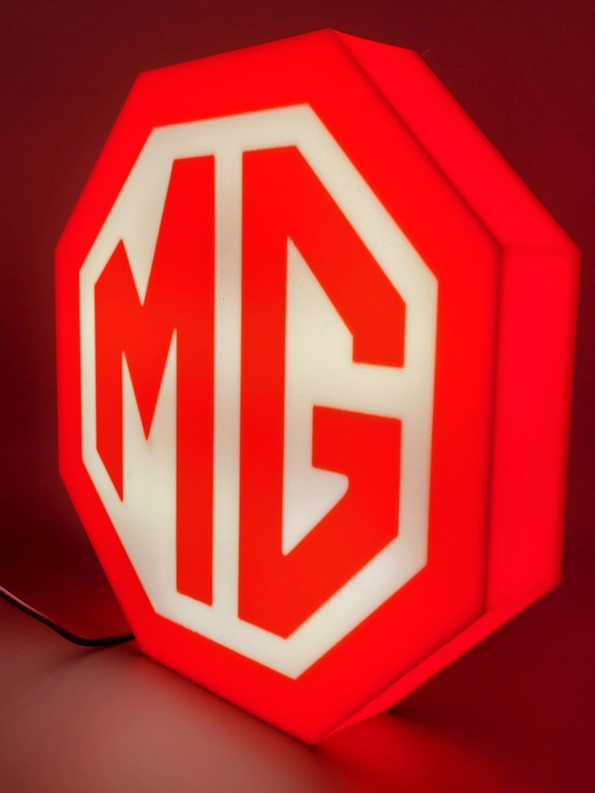 MG led light sign with illuminated logo viewed from side view 