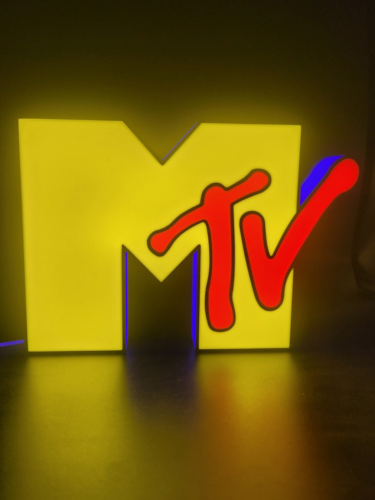 Mtv led light sign with illuminated logo viewed from straight on