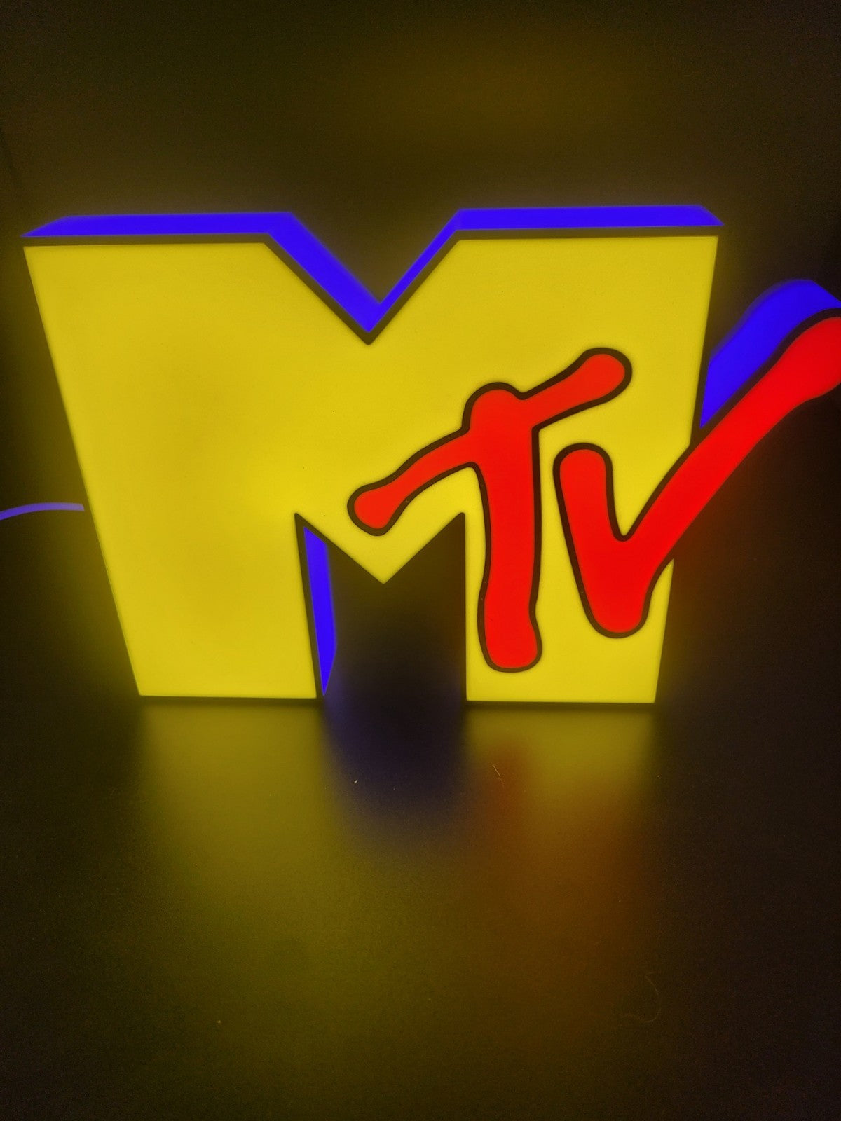 Mtv led light sign with illuminated logo viewed from straight on
