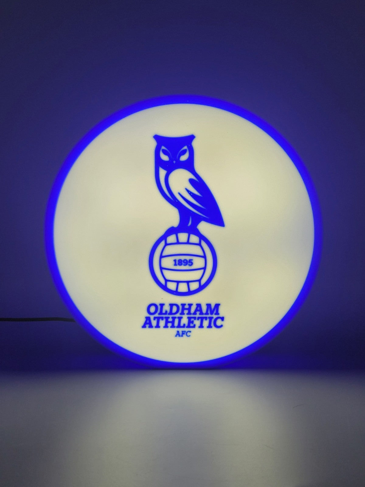 Oldham athletic AFC led light sign with illuminated logo viewed from straight on