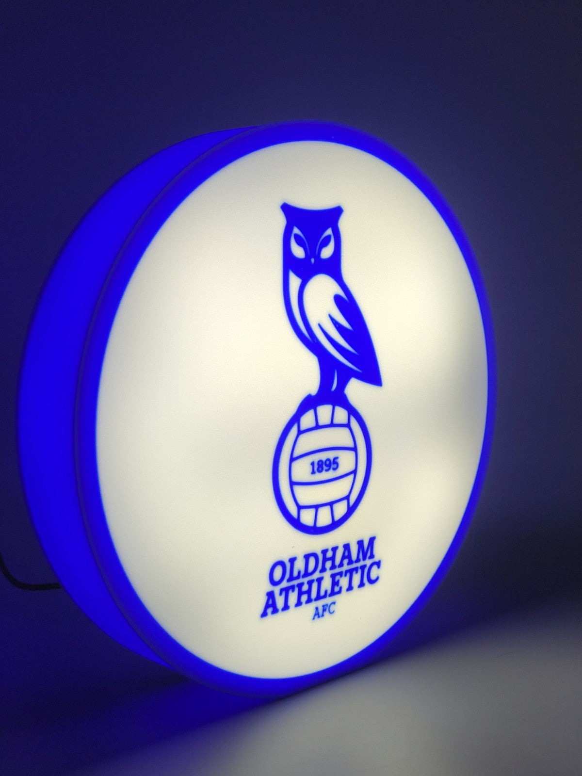 Oldham athletic AFC led light sign with illuminated logo viewed from side view