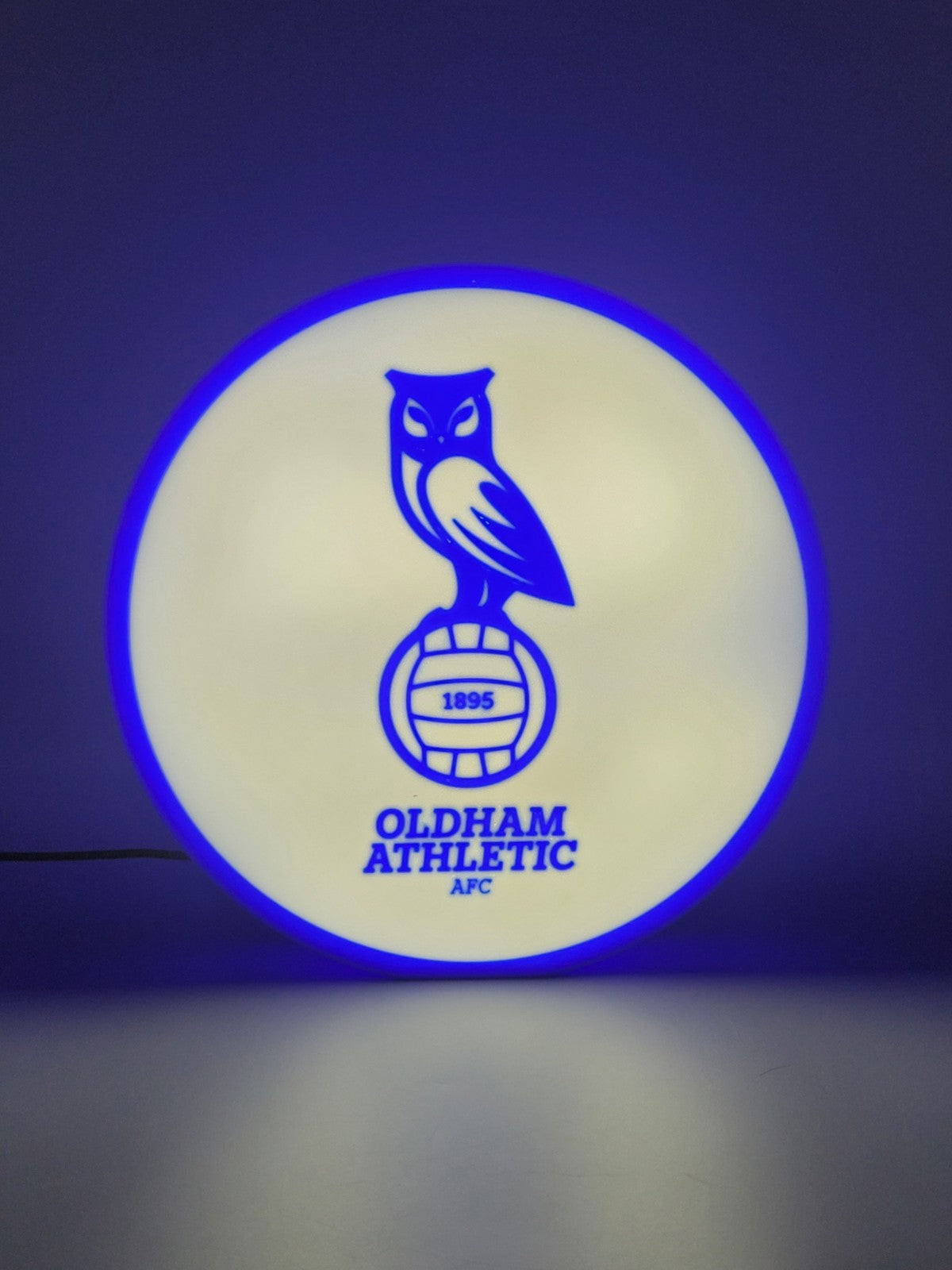 Oldham athletic AFC led light sign with illuminated logo viewed from straight on