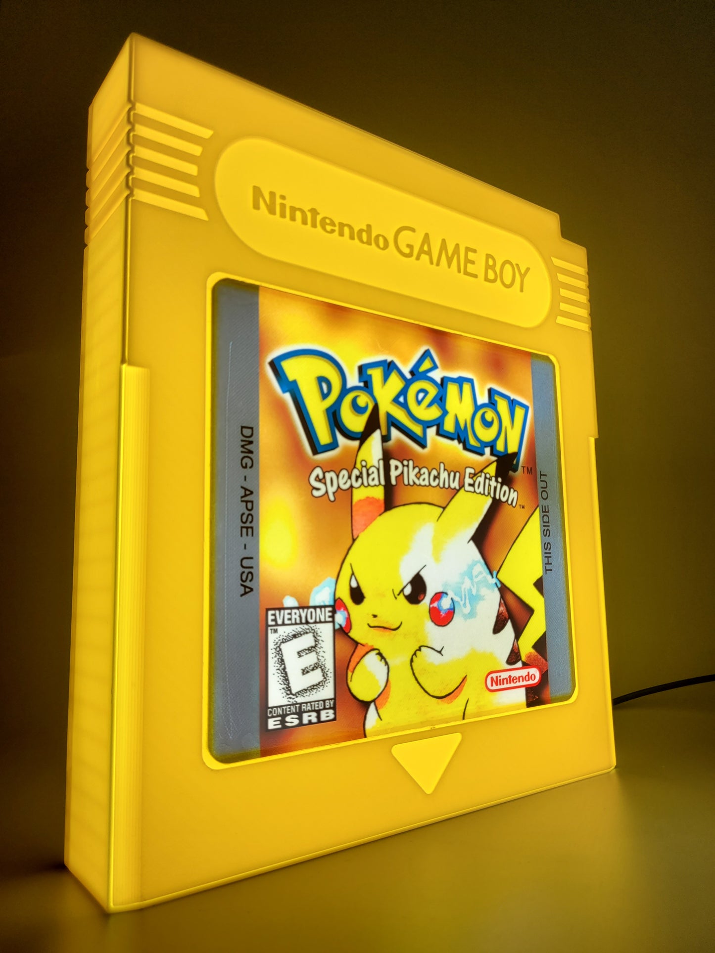 Yellow Game Boy with a Pokémon game cartridge on a dark background