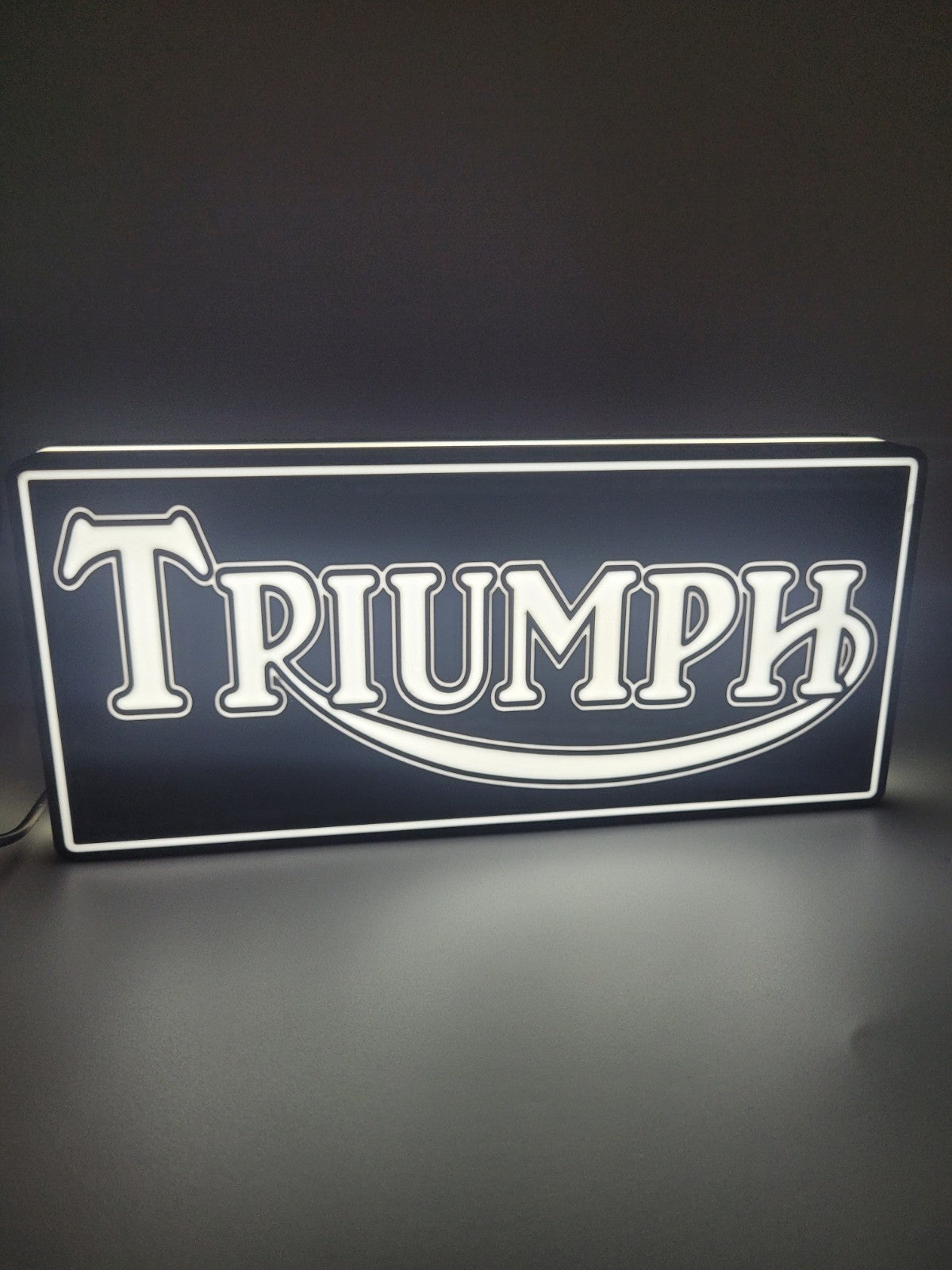 Triumph square LED light sign with illuminated logo viewed from straight on