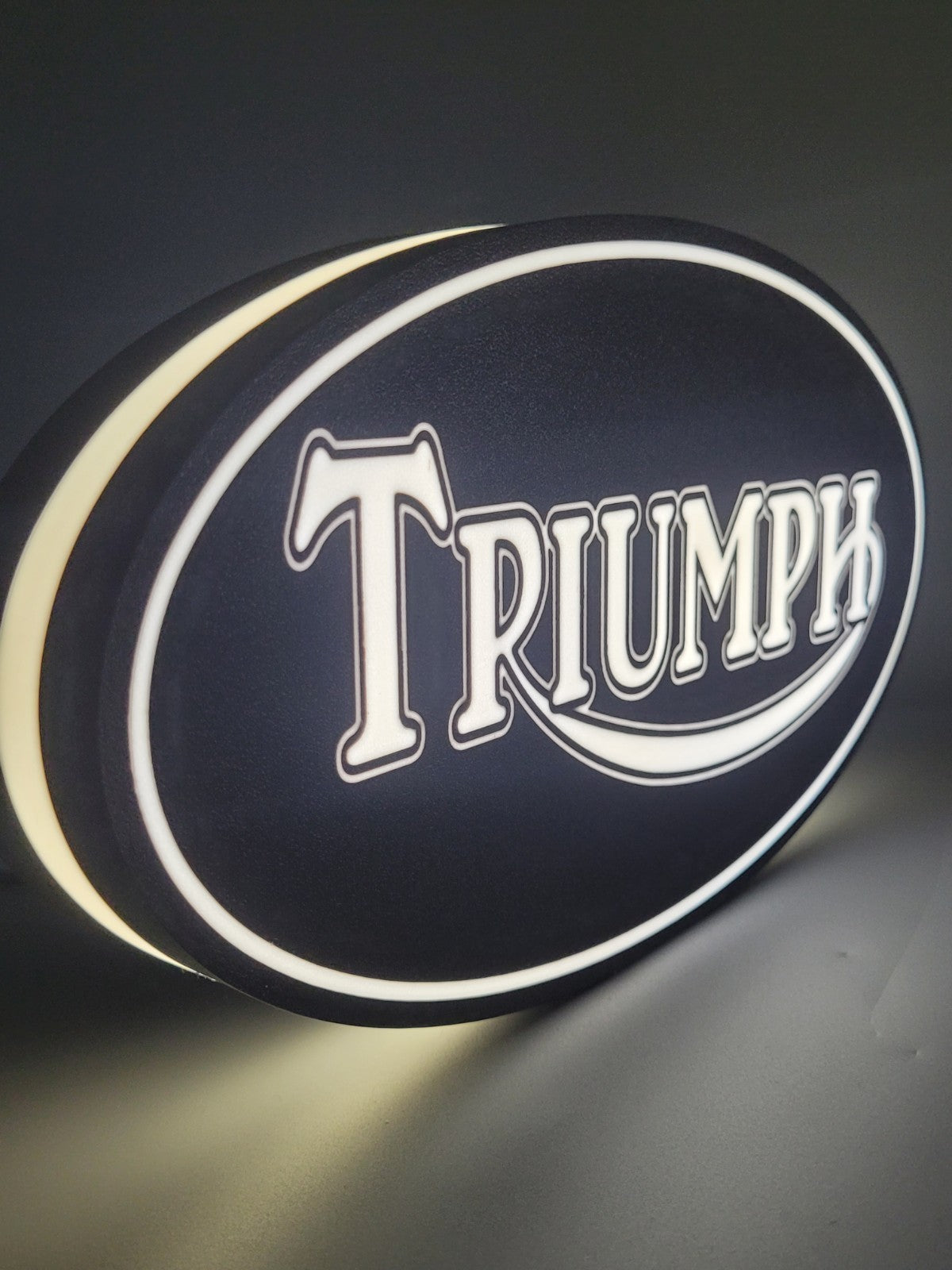 Triumph led light sign with illuminated logo viewed from side view